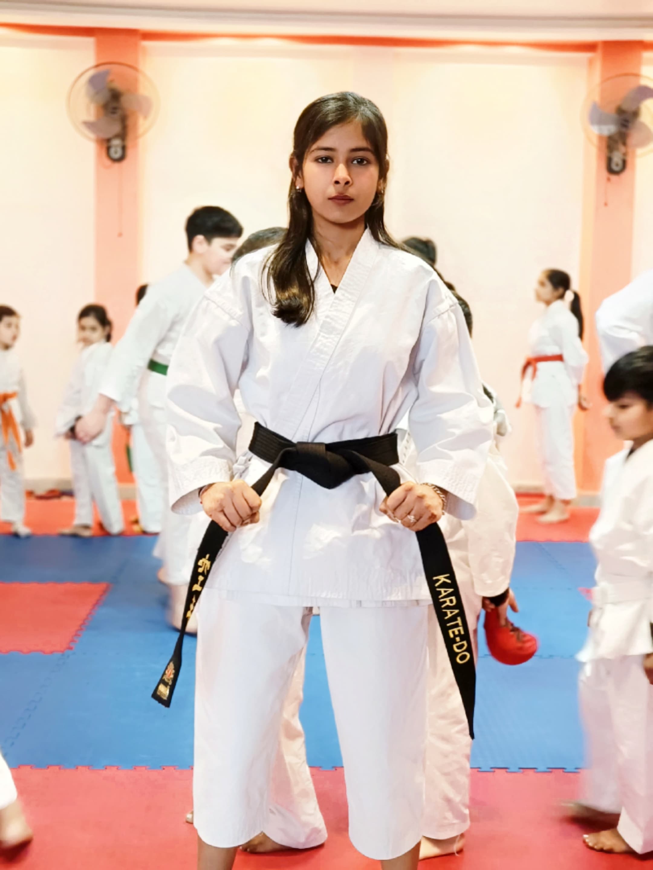 Manika Goel in her karate gi wearing her black belt